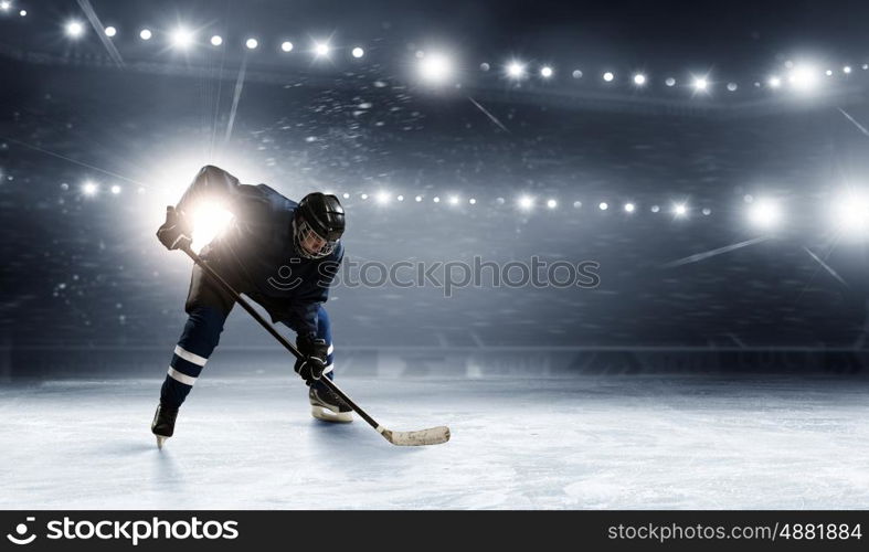 Ice hockey player at rink. Hockey player in lights at ice rink