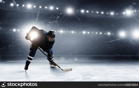 Ice hockey player at rink. Hockey player in lights at ice rink