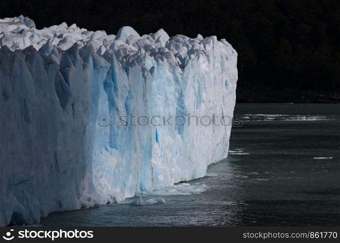 Ice mass of glacier peaks high above lake in Patagonia
