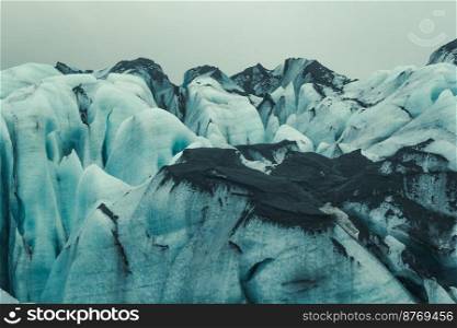 Ice mountain with black sand landscape photo. Beautiful nature scenery photography with gloomy sky on background. Idyllic scene. High quality picture for wallpaper, travel blog, magazine, article. Ice mountain with black sand landscape photo