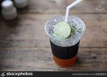 Ice tea with honey and lemon on wooden table