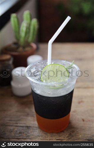 Ice tea with honey and lemon on wooden table