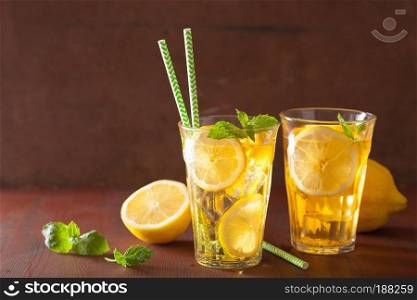 ice tea with lemon and mint on dark rustic background