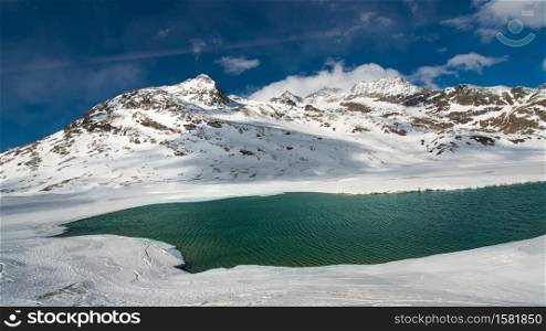Ice thaw in a high mountain landscape with a lake in spring
