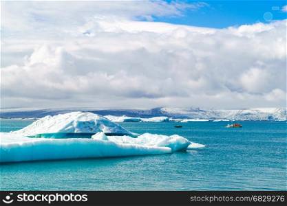 Iceberg and sightseeing boats in Jokulsarlon, a glacial river lagoon in southeast Iceland