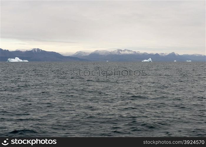 Icebergs around Disko Island in Greenland, Greenlandic seascape and landscape with mountains and water