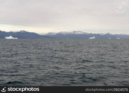 Icebergs around Disko Island in Greenland, Greenlandic seascape and landscape with mountains and water