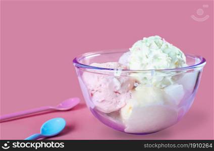 Icecream in bowl putting together with spoons on pink background. Fashion and Food concept.