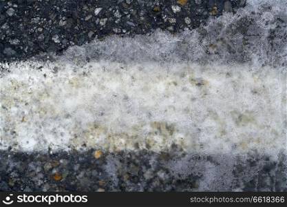 Iced asphalt road pavement detail in winter