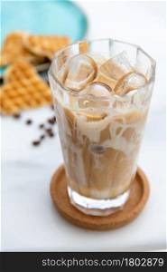 Iced caramel latte coffee in a tall glass with caramel syrup
