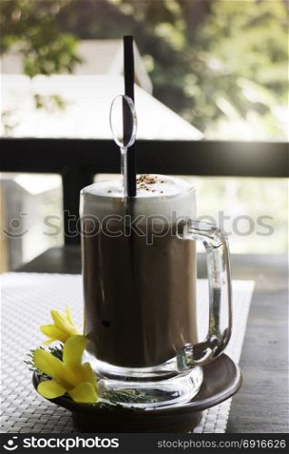 Iced coffee latte on balcony wooden table, stock photo