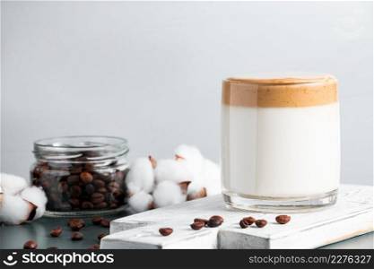 Iced dalgona coffee. A glass of trendy fluffy drink made from milk and whipped cream on a gray background. Place for text. Iced dalgona coffee. Glass of trendy fluffy drink made from milk and whipped cream on a gray background.
