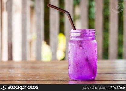 Iced drink in violet glass in coffee shop, stock photo