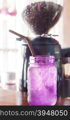 Iced drink in violet glass in coffee shop, stock photo