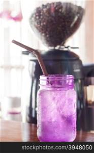 Iced drink in violet glass in coffee shop, stock photo