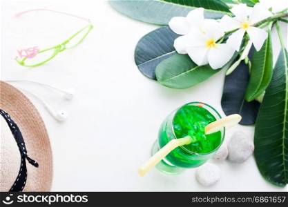 Iced green color drink on white background with plumeria flower, Summer concept with copy space