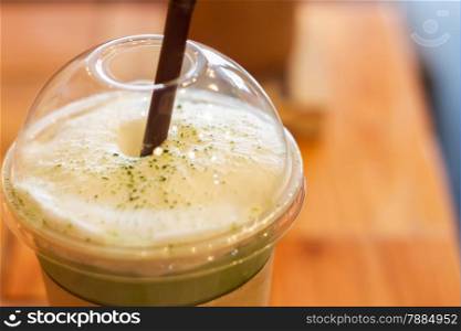 Iced green tea latte with milk foam, stock photo