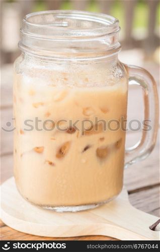 Iced milk coffee on wooden table, stock photo
