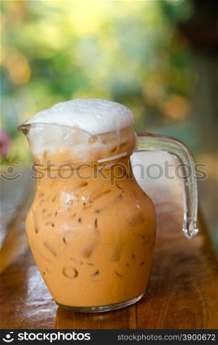 Iced Milk Tea with cup on a wooden table