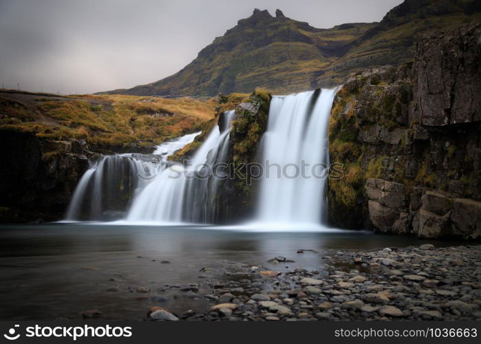 Iceland timelapse photography of waterfall and famous mountain. Kirkjufellsfoss and Kirkjufell in northern Iceland nature landscape