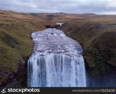 Iceland waterfall Skogafoss in Icelandic nature landscape. Famous tourist attractions and landmarks destination in Icelandic nature landscape on South Iceland. Aerial drone view of top waterfall.