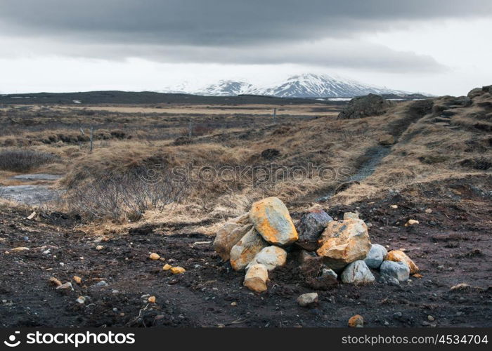 Icelandic landscape with rocks on a field in cloudy weather