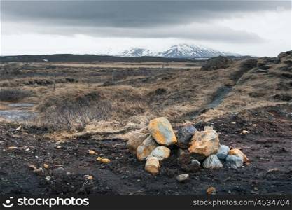Icelandic landscape with rocks on a field in cloudy weather