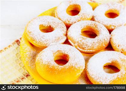 Icing homemade donuts on yellow plate. Sweet dessert pastry doughnuts. Hanukkah sweet donuts.