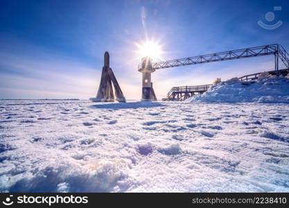 Icy frozen shore of the lake. Ice patterns and texture. Frosty winter time.. Light beacon or lighthouse in winter landscape at a dutch lake