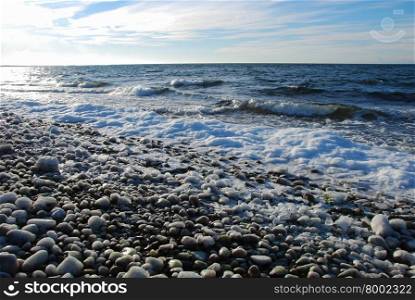 Icy pebbles by a coast in the Baltic Sea