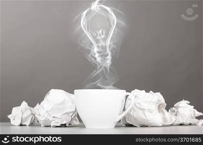 idea birth. crumpled wads and bulb silhouette on gray