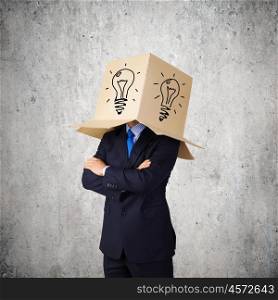 Idea concept. Businessman wearing on head carton box with drawing of bulb