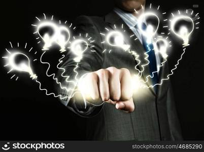 Idea concept. Close up of businessman grasping light bulbs in fist