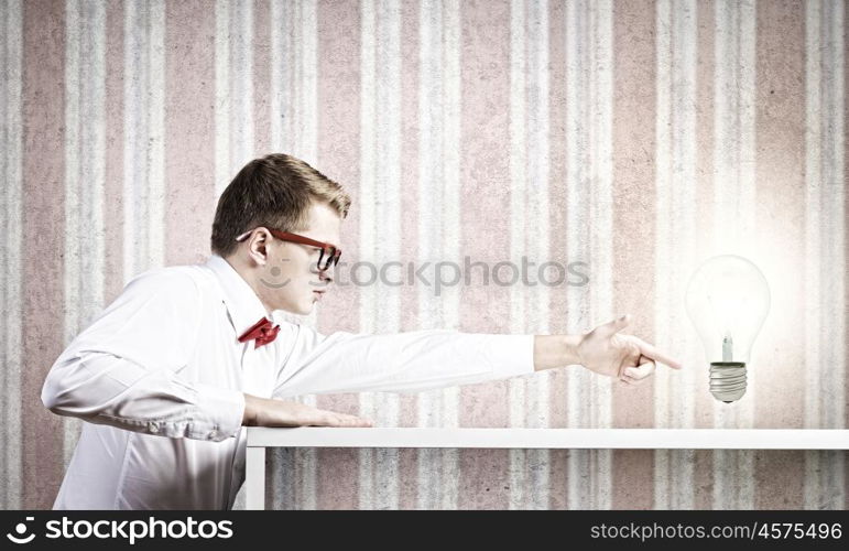 Idea concept. Half of face of young man looking out out from under the table