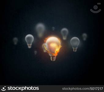Idea concept. Light bulb burning in flame on dark blue background.