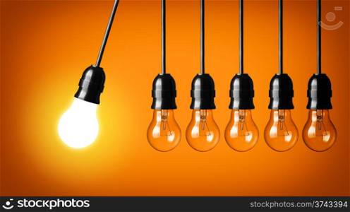 Idea concept on orange background. Perpetual motion with light bulbs