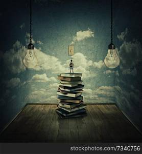 Idea concept with a boy standing on a pile of books trying to swich on the light bulbs, surrounded by concrete walls with clouds texture as thinking limitations. In search of knowlegde.