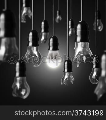 idea concept with broken bulbs and one glowing LED bulb
