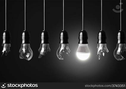 Idea concept with broken bulbs and one glowing LED bulb