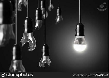 idea concept with broken bulbs and one LED glowing bulb