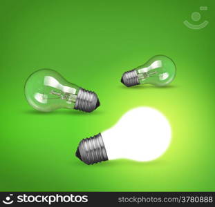 idea concept with glowing light bulb on green background