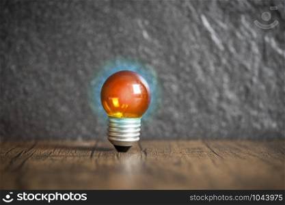 idea concept with orange light bulb and blue light on wooden with dark background