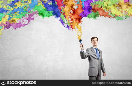 Idea concept. Young businessman with paint brush in hand