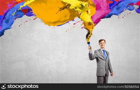 Idea concept. Young businessman with paint brush in hand