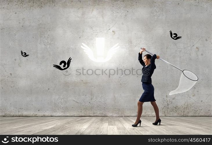 Idea concept. Young businesswoman catching flying marks with hoop