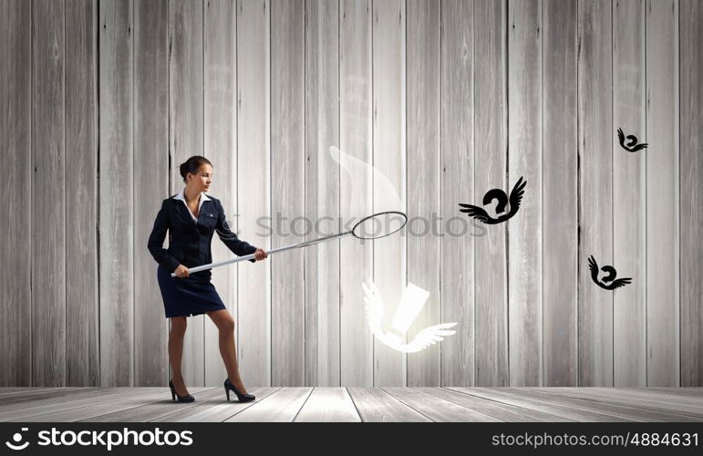 Idea concept. Young businesswoman catching flying marks with hoop