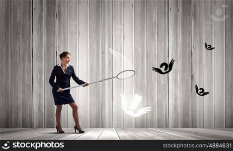 Idea concept. Young businesswoman catching flying marks with hoop