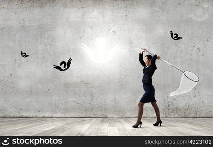 Idea concept. Young businesswoman catching flying marks with hoop