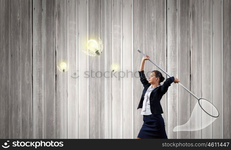 Idea concept. Young businesswoman catching light bulb with hoop