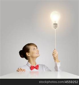 Idea concept. Young woman holding balloon shaped like electric bulb